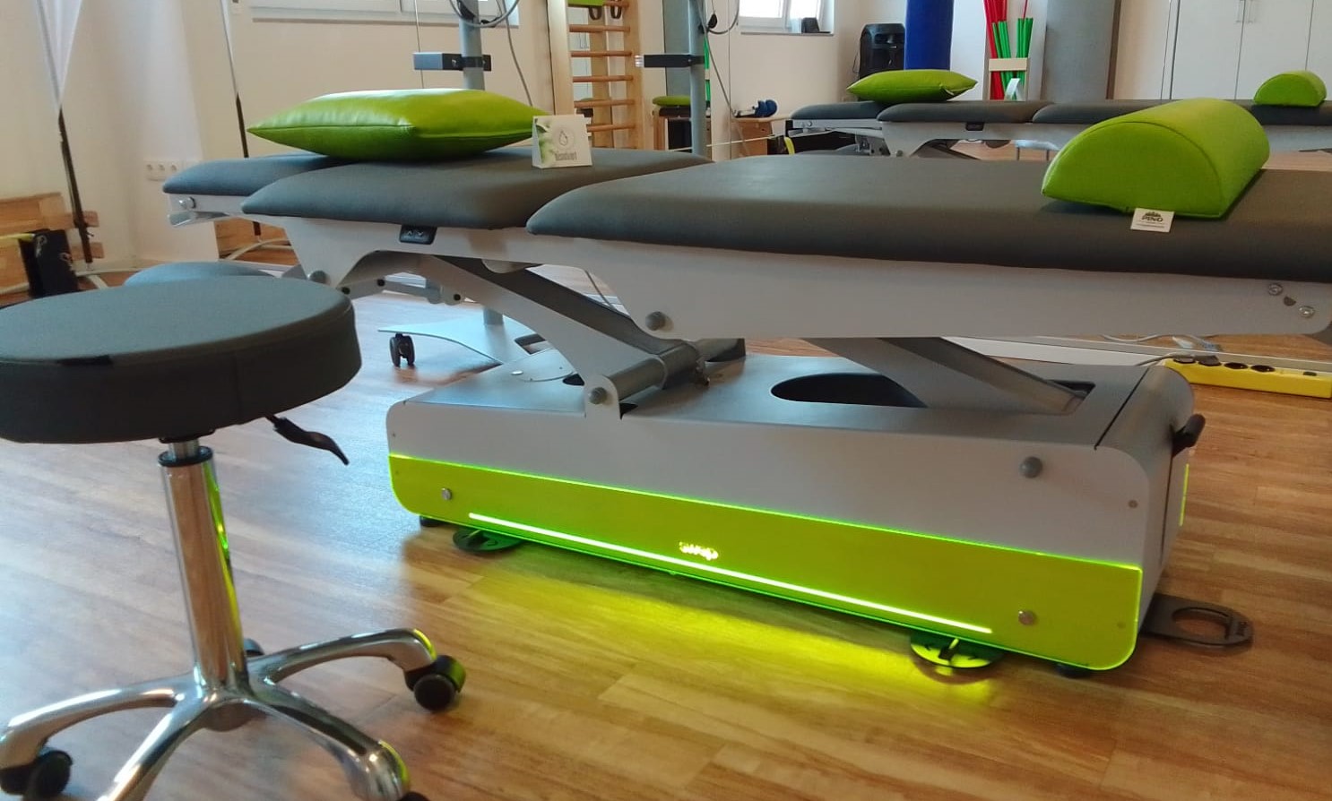 Moderne Behandlungsliegen in Grau und Grün im neuen Physiotherapie-Behandlungsraum