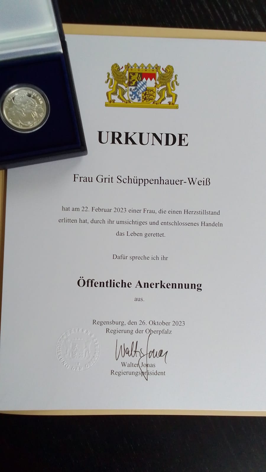 Urkunde mit bayerischem Wappen für öffentliche Anerkennung als Lebensretterin